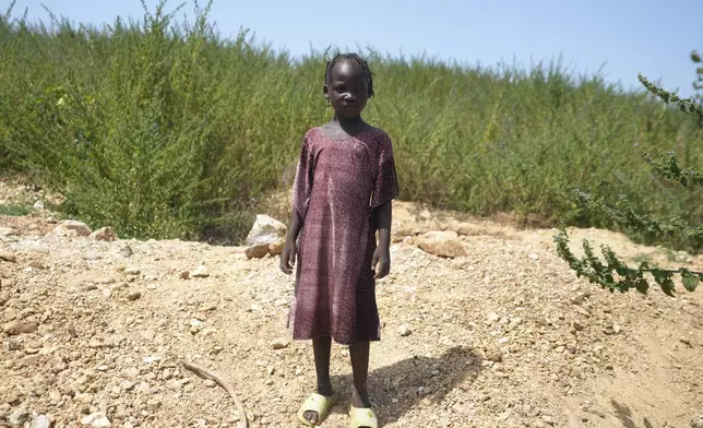 Juliet Samaniya, 6, poses for a photograph at an illegal lithium mining site where she works in Paseli, Nigeria, Tuesday, Nov 5, 2024. (AP Photo/Sunday Alamba)