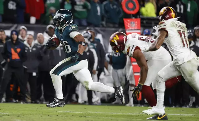 FILE - Philadelphia Eagles running back Saquon Barkley, left, runs for a touchdown during the second half of an NFL football game against the Washington Commanders Thursday, Nov. 14, 2024, in Philadelphia. (AP Photo/Laurence Kesterson, File)