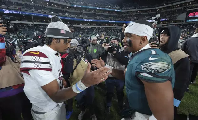 FILE - Philadelphia Eagles quarterback Jalen Hurts (1) and Washington Commanders quarterback Jayden Daniels shake hands following an NFL football game Thursday, Nov. 14, 2024, in Philadelphia. The Eagles won 26-18. (AP Photo/Chris Szagola, File)