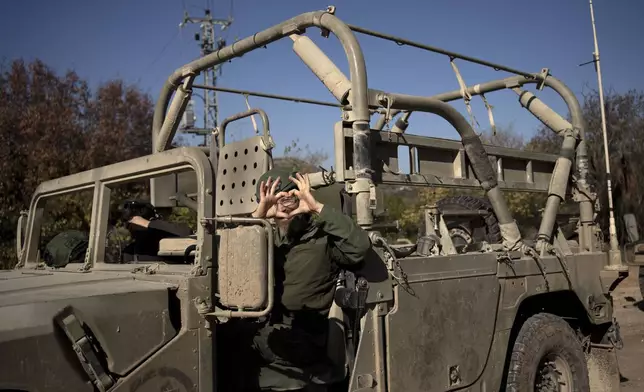 An Israeli soldier gestures from his vehicle in northern Israel, near the border with Lebanon, during a ceasefire, Tuesday, Dec. 3, 2024. (AP Photo/Maya Alleruzzo)