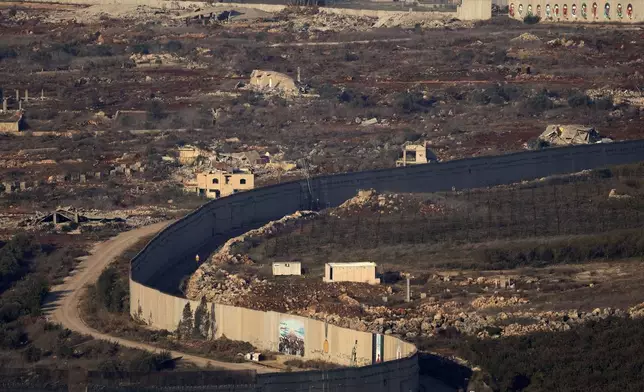 Destroyed buildings in the village of Kfar Kila, southern Lebanon, beside the separation barrier between Israel and Lebanon, are seen from northern Israel, Tuesday, Dec. 3, 2024. (AP Photo/Maya Alleruzzo)