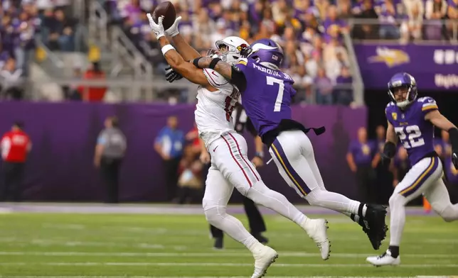 Arizona Cardinals wide receiver Michael Wilson (14) catches a pass over Minnesota Vikings cornerback Byron Murphy Jr. (7) during the first half of an NFL football game Sunday, Dec. 1, 2024, in Minneapolis. (AP Photo/Bruce Kluckhohn)