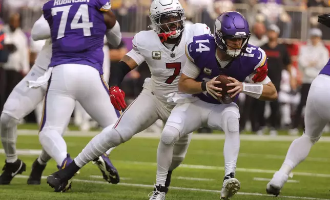 Minnesota Vikings quarterback Sam Darnold (14) is sacked by Arizona Cardinals linebacker Kyzir White (7) during the first half of an NFL football game Sunday, Dec. 1, 2024, in Minneapolis. (AP Photo/Bruce Kluckhohn)