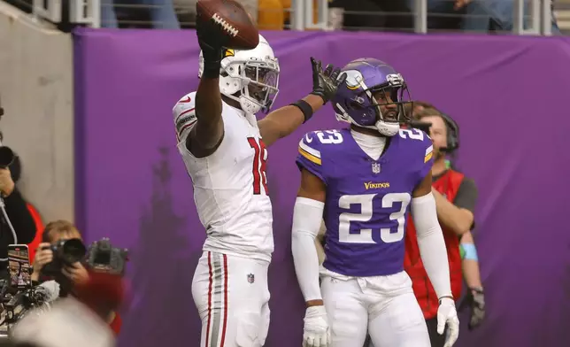 Arizona Cardinals wide receiver Marvin Harrison Jr. (18) celebrates in front of Minnesota Vikings cornerback Fabian Moreau (23) after catching a 15-yard touchdown pass during the second half of an NFL football game Sunday, Dec. 1, 2024, in Minneapolis. (AP Photo/Bruce Kluckhohn)