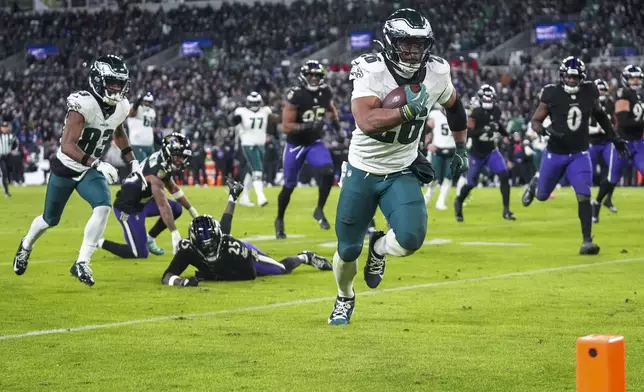 Philadelphia Eagles running back Saquon Barkley runs for a touchdown against the Baltimore Ravens during the second half of an NFL football game, Sunday, Dec. 1, 2024, in Baltimore. (AP Photo/Stephanie Scarbrough)