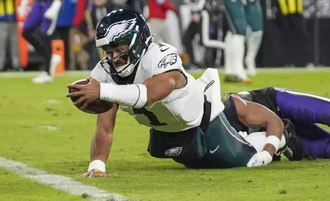 Philadelphia Eagles quarterback Jalen Hurts tries to stretch to score on a keeper against the Baltimore Ravens during the first half of an NFL football game, Sunday, Dec. 1, 2024, in Baltimore. (AP Photo/Stephanie Scarbrough)