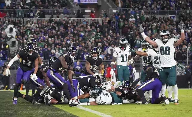 Philadelphia Eagles quarterback Jalen Hurts, bottom center, recovers his fumble to score a touchdown on a keeper against the Baltimore Ravens during the first half of an NFL football game, Sunday, Dec. 1, 2024, in Baltimore. (AP Photo/Stephanie Scarbrough)