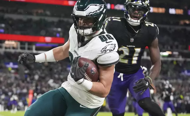 Philadelphia Eagles tight end Dallas Goedert (88) scores a touchdown in front of Baltimore Ravens cornerback Brandon Stephens (21) during the first half of an NFL football game, Sunday, Dec. 1, 2024, in Baltimore. (AP Photo/Stephanie Scarbrough)