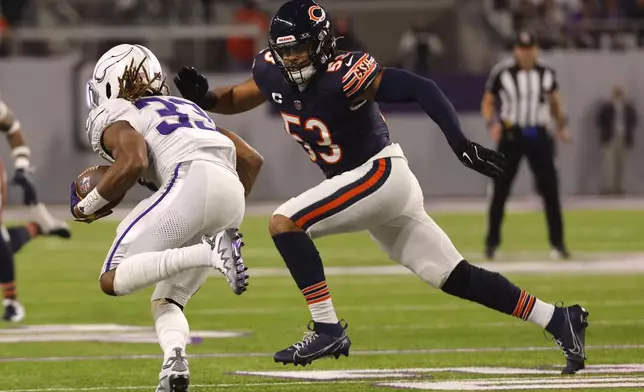 Minnesota Vikings running back Aaron Jones (33) runs from Chicago Bears linebacker T.J. Edwards (53) during the first half of an NFL football game, Monday, Dec. 16, 2024, in Minneapolis. (AP Photo/Bruce Kluckhohn)