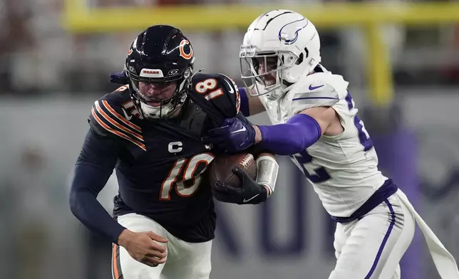 Chicago Bears quarterback Caleb Williams runs from Minnesota Vikings safety Harrison Smith, right, during the first half of an NFL football game, Monday, Dec. 16, 2024, in Minneapolis. (AP Photo/Abbie Parr)