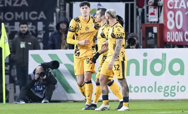 Inter Milan's Alessandro Bastoni, left, celebrates with teammates after scoring the opening goal during the Serie A soccer match between Cagliari Calcio and Inter Milan at the Unipol Domus stadium in Cagliari, Italy, Saturday, Dec. 28, 2024. (Gianluca Zuddas/LaPresse via AP)