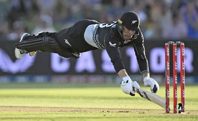 New Zealand's Glenn Phillips dives to make his ground during the first Twenty20 international cricket match between New Zealand and Sri Lanka at Mt Maunganui, New Zealand on Saturday, Dec. 28, 2024. (Andrew Cornaga/Photosport via AP)
