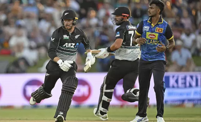 New Zealand's Glenn Phillips runs as Sri Lanka's Matheesha Pathirana looks on during the first Twenty20 international cricket match between New Zealand and Sri Lanka at Mt Maunganui, New Zealand on Saturday, Dec. 28, 2024. (Andrew Cornaga/Photosport via AP)