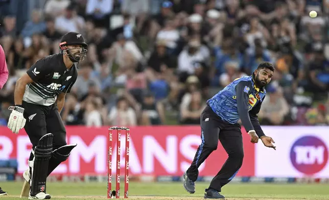 Sri Lanka's Wanindu Hasaranga bowls as New Zealand's New Zealand's Daryl Mitchell looks on during the first Twenty20 international cricket match between New Zealand and Sri Lanka at Mt Maunganui, New Zealand on Saturday, Dec. 28, 2024. (Andrew Cornaga/Photosport via AP)