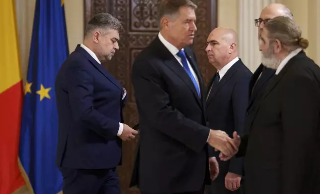 Romanian President Klaus Iohannis, right, shakes hands with government coalition leaders as Prime Minister designate Marcel Ciolacu, left, walks after being nominated to form the new government in Bucharest, Romania, Monday, Dec. 23, 2024. (AP Photo/Vadim Ghirda)