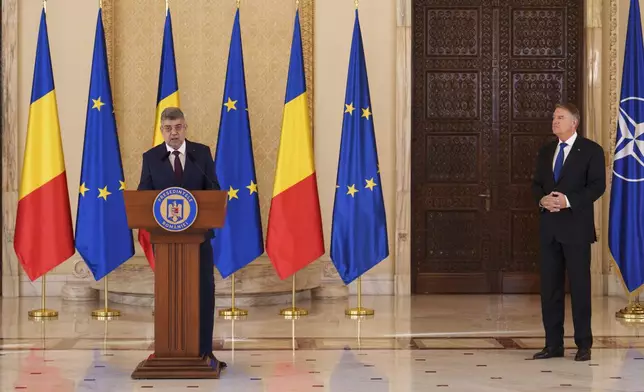 Prime Minister designate Marcel Ciolacu, left, speaks after Romanian President Klaus Iohannis, right, nominated him to form the new government in Bucharest, Romania, Monday, Dec. 23, 2024. (AP Photo/Vadim Ghirda)