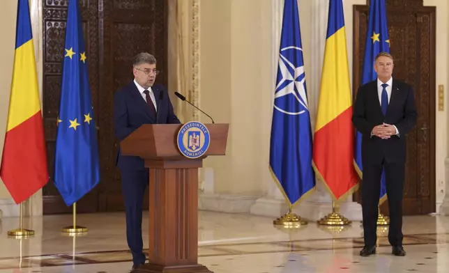 Prime Minister designate Marcel Ciolacu, left, speaks after Romanian President Klaus Iohannis, right, nominated him to form the new government in Bucharest, Romania, Monday, Dec. 23, 2024. (AP Photo/Vadim Ghirda)