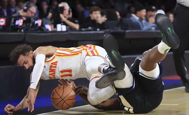 Atlanta Hawks guard Trae Young (11) collides into Milwaukee Bucks forward Khris Middleton, right, during the first half of a semifinal game in the NBA Cup basketball tournament Saturday, Dec. 14, 2024, in Las Vegas. (AP Photo/Ian Maule)