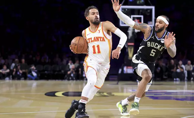 Atlanta Hawks guard Trae Young (11) drives past Milwaukee Bucks guard Gary Trent Jr. (5) during the first half of a semifinal game in the NBA Cup basketball tournament Saturday, Dec. 14, 2024, in Las Vegas. (AP Photo/Ian Maule)