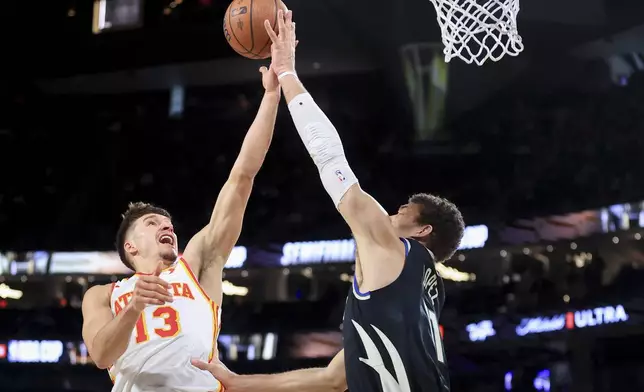 Milwaukee Bucks center Brook Lopez, right, blocks Atlanta Hawks guard Bogdan Bogdanovic (13) during the first half of a semifinal game in the NBA Cup basketball tournament Saturday, Dec. 14, 2024, in Las Vegas. (AP Photo/Ian Maule)