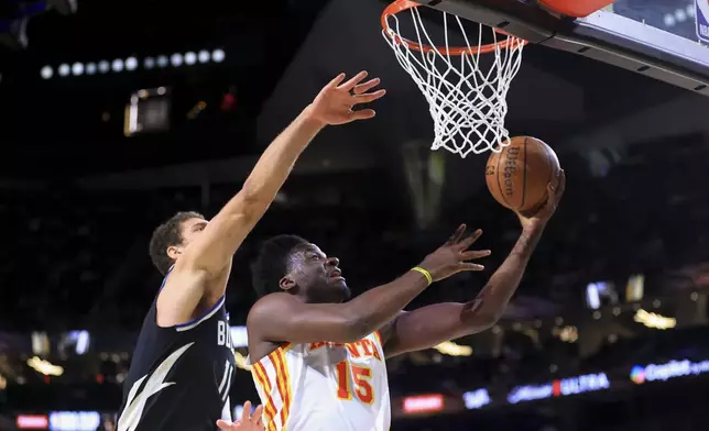 Atlanta Hawks center Clint Capela (15) shoots against Milwaukee Bucks center Brook Lopez (11) during the first half of a semifinal game in the NBA Cup basketball tournament Saturday, Dec. 14, 2024, in Las Vegas. (AP Photo/Ian Maule)