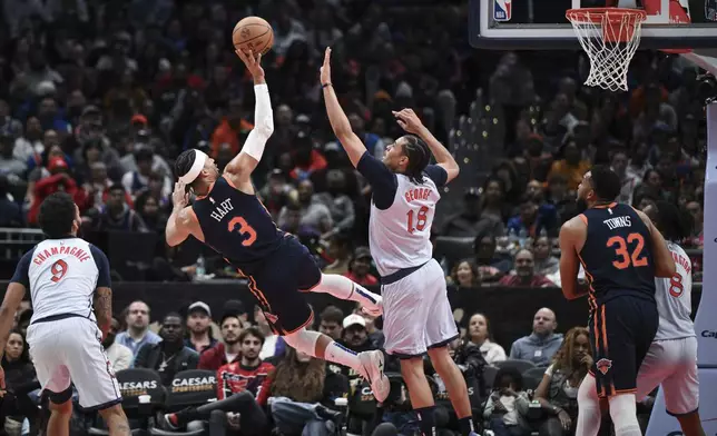 New York Knicks guard Josh Hart (3) shoots the ball and is fouled by Washington Wizards forward Kyshawn George (18) during the first half of an NBA basketball game, Monday, Dec. 30, 2024, in Washington. (AP Photo/Terrance Williams)