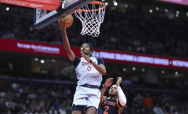 Washington Wizards guard Bilal Coulibaly (0) goes to the basket for a lay up as New York Knicks guard Miles McBride (2) defends during the first half of an NBA basketball game, Monday, Dec. 30, 2024, in Washington. (AP Photo/Terrance Williams)