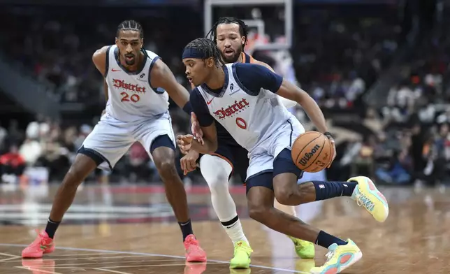 Washington Wizards guard Bilal Coulibaly (0) drives to the basket on a pick set by forward Alexandre Sarr (20) as New York Knicks guard Jalen Brunson defends during the first half of an NBA basketball game, Monday, Dec. 30, 2024, in Washington. (AP Photo/Terrance Williams)