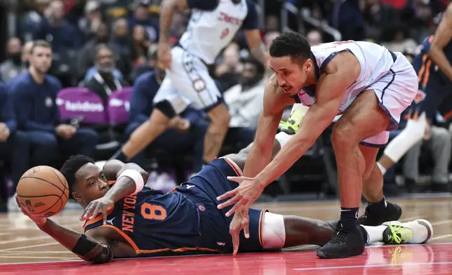 New York Knicks forward OG Anunoby (8) grabs a loose ball away from Washington Wizards guard Malcolm Brogdon during the first half of an NBA basketball game, Monday, Dec. 30, 2024, in Washington. (AP Photo/Terrance Williams)