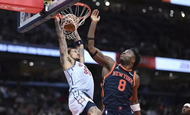 Washington Wizards forward Kyle Kuzma (33) dunks over New York Knicks forward OG Anunoby (8) during the first half of an NBA basketball game, Monday, Dec. 30, 2024, in Washington. (AP Photo/Terrance Williams)