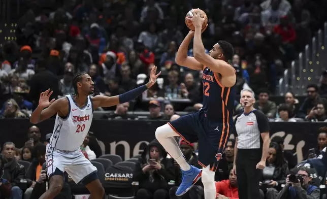 New York Knicks center Karl-Anthony Towns shoots the ball as Washington Wizards forward Alexandre Sarr (20) defends during the first half of an NBA basketball game, Monday, Dec. 30, 2024, in Washington. (AP Photo/Terrance Williams)