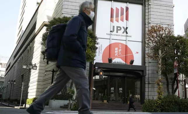 People walk in front of Tokyo Stock Exchange building Wednesday, Dec. 25, 2024, in Tokyo. (AP Photo/Eugene Hoshiko)