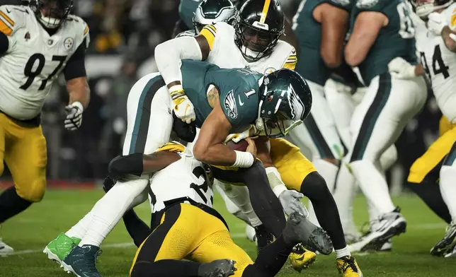 Philadelphia Eagles quarterback Jalen Hurts (1) is tackled by Pittsburgh Steelers' Patrick Queen (6) and Damontae Kazee (23) during the first half of an NFL football game Sunday, Dec. 15, 2024, in Philadelphia. (AP Photo/Matt Slocum)