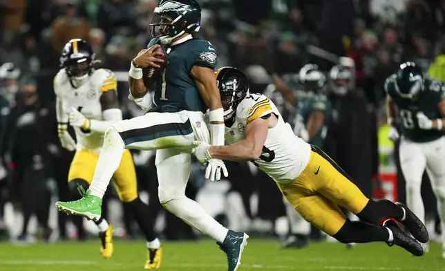 Philadelphia Eagles quarterback Jalen Hurts (1) is tackled by Pittsburgh Steelers linebacker T.J. Watt (90) during the second half of an NFL football game Sunday, Dec. 15, 2024, in Philadelphia. (AP Photo/Derik Hamilton)