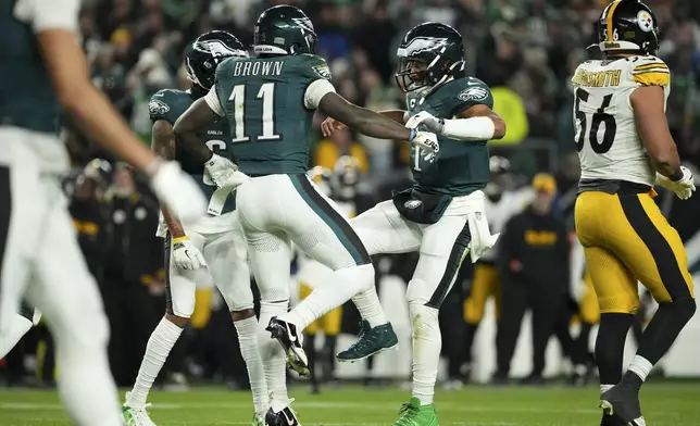 Philadelphia Eagles wide receiver A.J. Brown (11) celebrates his touchdown with teammates Jalen Hurts (1) and DeVonta Smith during the first half of an NFL football game against the Pittsburgh Steelers on Sunday, Dec. 15, 2024, in Philadelphia. (AP Photo/Matt Slocum)