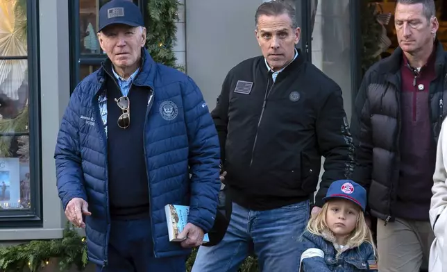 President Joe Biden accompanied by his son Hunter Biden and his grandson Beau leave a book store as they walk in downtown Nantucket Mass., Friday, Nov. 29, 2024. (AP Photo/Jose Luis Magana)