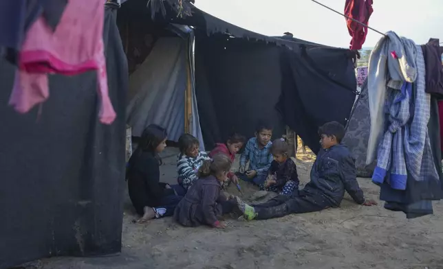 Grandchildren of Reda Abu Zarada, displaced from Jabaliya in northern Gaza, play next to their tent at a camp in Khan Younis, Gaza Strip, Thursday, Dec. 19, 2024. (AP Photo/Abdel Kareem Hana)