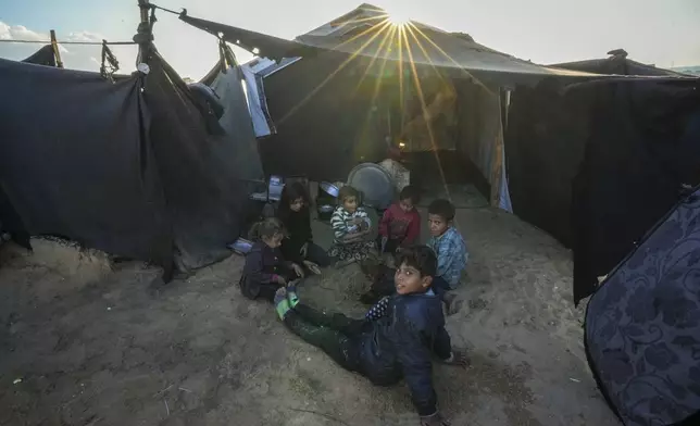 Grandchildren of Reda Abu Zarada, displaced from Jabaliya in northern Gaza, play next to their tent at a camp in Khan Younis, Gaza Strip, Thursday, Dec. 19, 2024. (AP Photo/Abdel Kareem Hana)