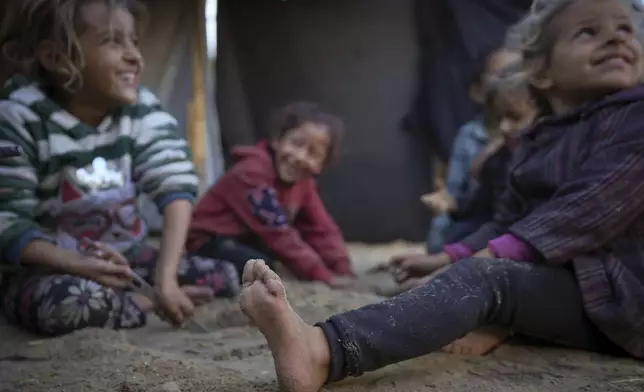 Grandchildren of Reda Abu Zarada, displaced from Jabaliya in northern Gaza, play next to their tent at a camp in Khan Younis, Gaza Strip, Thursday, Dec. 19, 2024. (AP Photo/Abdel Kareem Hana)