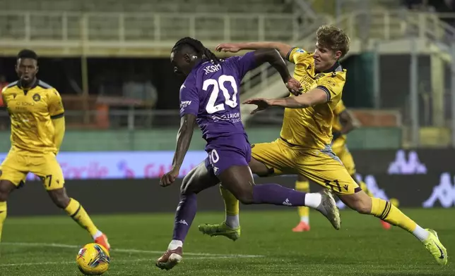 Fiorentina's Moise Kean is challenged by Udinese's Thomas Kristensen, right, during the Italian Serie A soccer match between Fiorentina and Udinese, Artemio Franchi Stadium in Florence, Italy, Monday Dec. 23, 2024 (Massimo Paolone/LaPresse via AP)