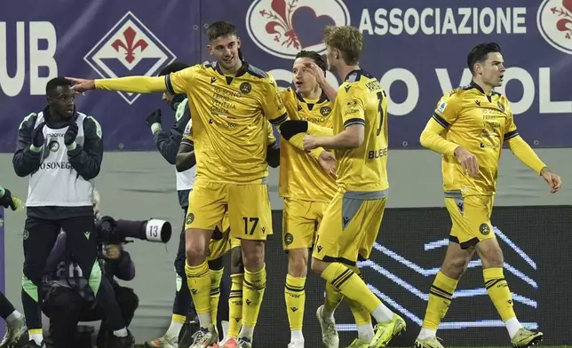 Udinese's Lorenzo Lucca, left, celebrates after scoring during the Italian Serie A soccer match between Fiorentina and Udinese, Artemio Franchi Stadium in Florence, Italy, Monday Dec. 23, 2024 (Massimo Paolone/LaPresse via AP)