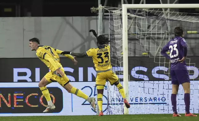 Udinese's Lorenzo Lucca, left, celebrates after scoring his side's opening goal during the Italian Serie A soccer match between Fiorentina and Udinese, Artemio Franchi Stadium in Florence, Italy, Monday Dec. 23, 2024 (Massimo Paolone/LaPresse via AP)