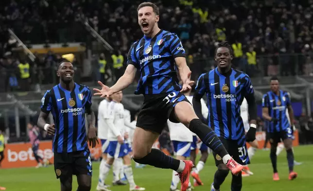 Inter Milan's Carlos Augusto, center, celebrates after scoring against Como during a Serie A soccer match between Inter Milan and Como at the San Siro stadium in Milan, Italy, Monday, Dec. 23, 2024. (AP Photo/Luca Bruno)