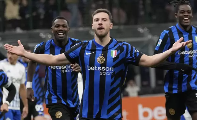 Inter Milan's Carlos Augusto, center, celebrates after scoring against Como during a Serie A soccer match between Inter Milan and Como at the San Siro stadium in Milan, Italy, Monday, Dec. 23, 2024. (AP Photo/Luca Bruno)