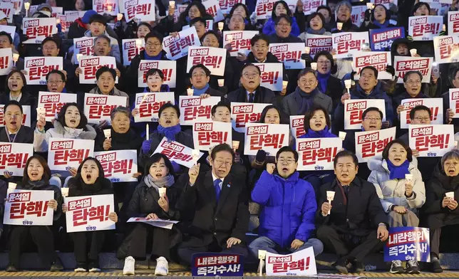 South Korea's main opposition Democratic Party leader Lee Jae-myung, bottom center left, and his party members stage a rally against the President Yoon Suk Yeol at the National Assembly in Seoul, South Korea, Wednesday, Dec. 4, 2024. The signs read "Yoon Suk Yeol should resign." (Ryu Hyung-seok/Yonhap via AP)