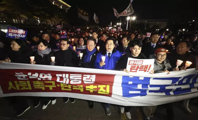 South Korea's main opposition Democratic Party leader Lee Jae-myung, center left, marches with his party members during a rally against the President Yoon Suk Yeol at the National Assembly in Seoul, South Korea, Wednesday, Dec. 4, 2024. The signs read "Yoon Suk Yeol should resign." (Ryu Hyung-seok/Yonhap via AP)