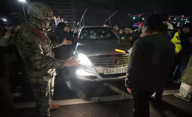 People bock a martial law vehicle as they gather to demand South Korean President Yoon Suk Yeol to step down in front of the National Assembly in Seoul, South Korea, Wednesday, Dec. 4, 2024. (AP Photo/Ahn Young-joon)