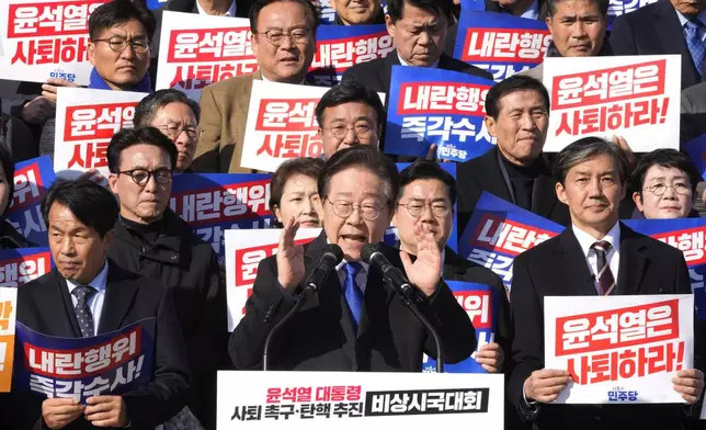 South Korea's main opposition Democratic Party leader Lee Jae-myung, bottom center, speaks during a rally against President Yoon Suk Yeol at the National Assembly in Seoul, South Korea, Wednesday, Dec. 4, 2024. The signs read "Yoon Suk Yeol should resign." (AP Photo/Ahn Young-joon)