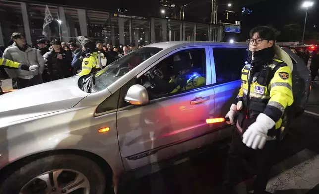 Military vehicles is escorted by police officers outside of the National Assembly in Seoul, South Korea, Wednesday, Dec. 4, 2024. (AP Photo/Lee Jin-man)