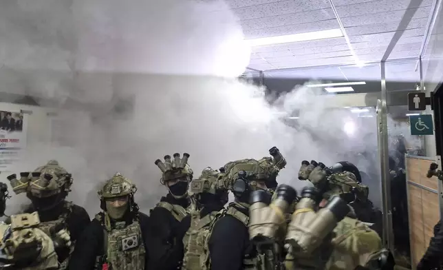 A National Assembly staff sprays fire extinguishers to block soldiers entering the main hall of the National Assembly in Seoul, South Korea, Wednesday, Dec. 4, 2024. (Jo Da-un/Yonhap via AP)